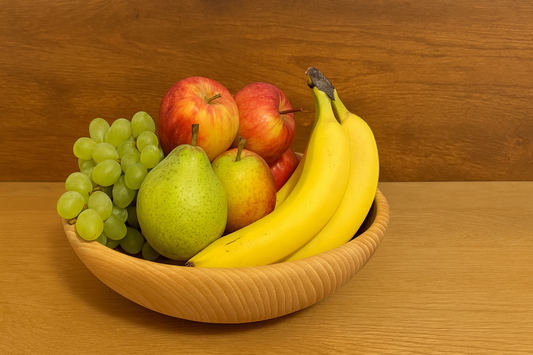 Naturalna miska drewniana z parzonego buku 26 cm – wypełniona jabłkami, bananami, winogronami i gruszkami, ustawiona na stole – produkt ekologiczny od Chłopcy z Rancza.