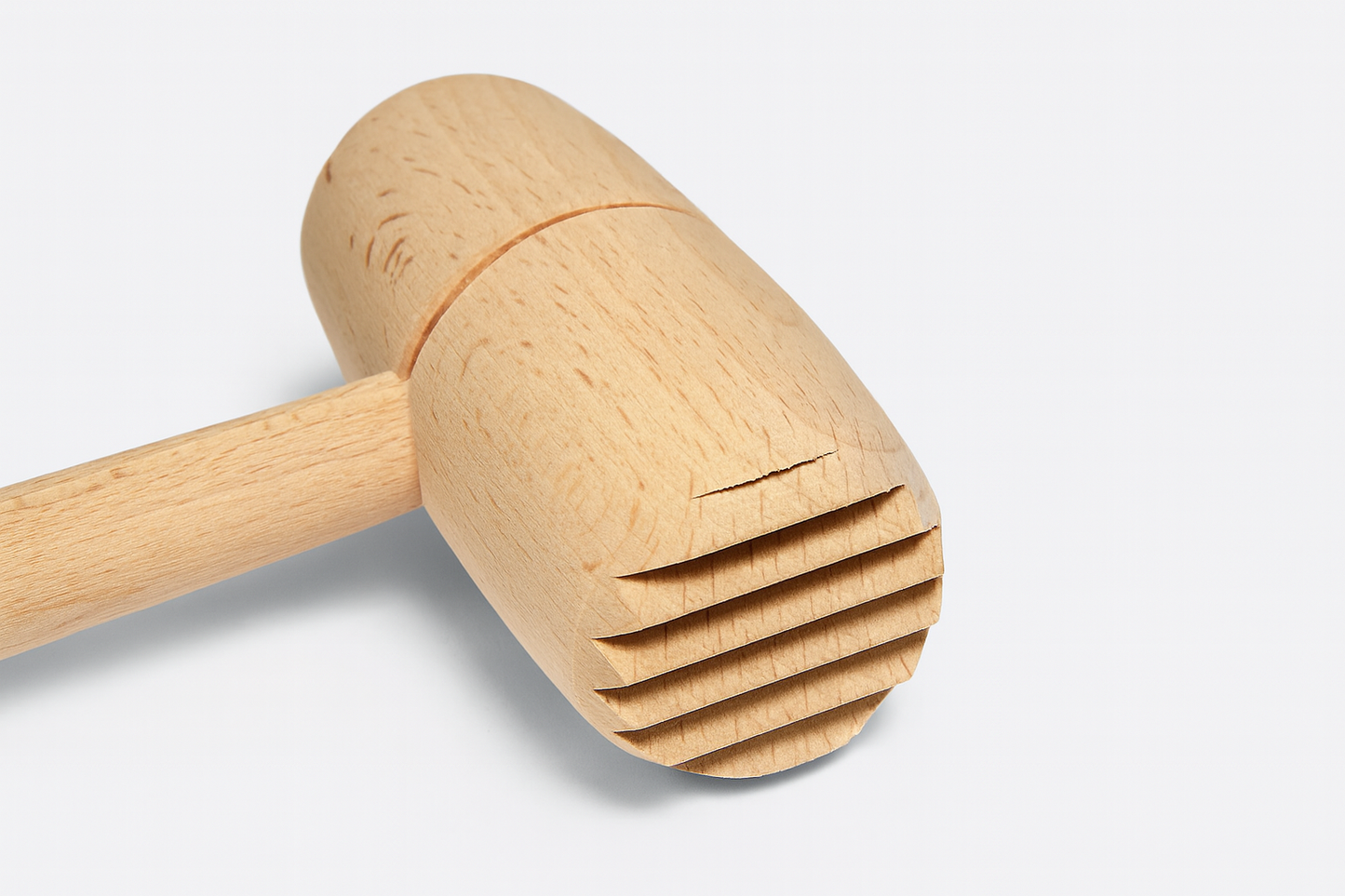 Drewniany tłuczek do mięsa z okrągłą głowicą i żłobioną powierzchnią roboczą – wykonany z naturalnego, jasnego drewna bukowego, idealny do codziennego użytku w kuchni.