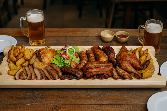 Gigantyczne koryto drewniane wypełnione pieczonym drobiem, żeberkami, kiełbasami, ziemniakami i warzywami, ustawione na rustykalnym stole. Obok kufle piwa i miseczki z sosami.