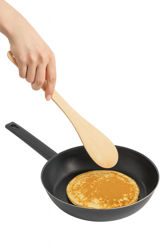 Drewniana łopatka do naleśników w kobiecej dłoni obracająca złocistego naleśnika na czarnej patelni – Chłopcy z Rancza / Ranch Boys
