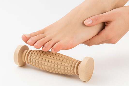 Drewniany masażer do stóp z wypukłą powierzchnią i licznymi wypustkami, na którym spoczywa kobieca stopa widziana od góry. Paznokcie delikatnie pomalowane, skóra gładka, tło białe, miękkie oświetlenie. Zdjęcie produktowe do e-commerce, pokazujące sposób użycia masażera. Chłopcy z Rancza.