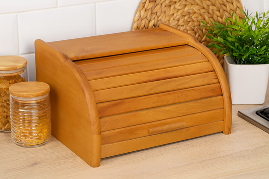 Elegancki chlebak drewniany stojący na blacie kuchennym w naturalnej aranżacji z rośliną i słoikami.