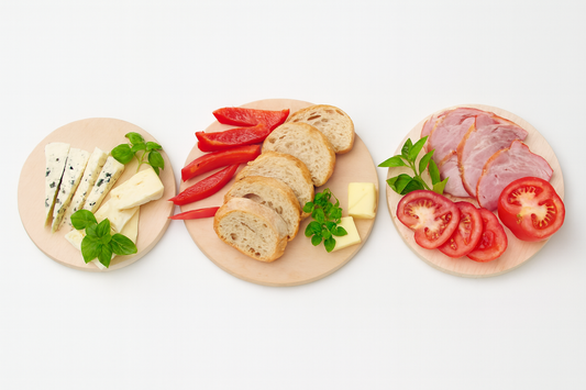 Trzy okrągłe deski z litego drewna bukowego z serami, pieczywem, wędlinami i warzywami – elegancka prezentacja produktów Chłopcy z Rancza.